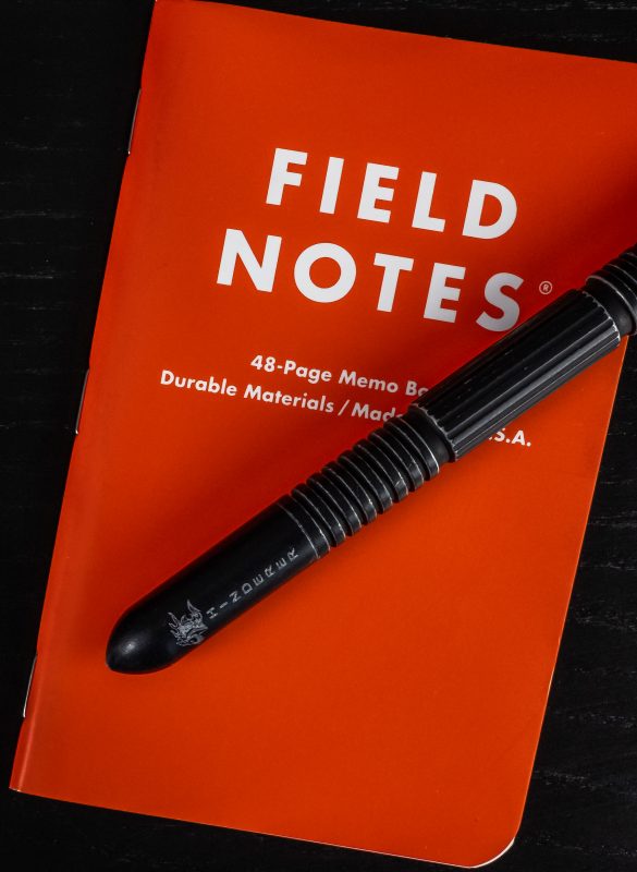a pen sitting on top of a red book.