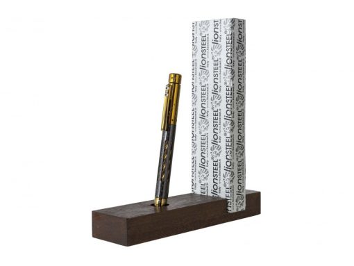 The Lionsteel Nyala Titanium/Carbon Fiber Pen (Bronze Shine) is sitting on top of a wooden stand.