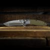 The Benchmade - 496 Vector 20CV Blade OD Green G-10 Handle sitting on top of a wooden table.