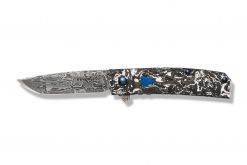 A Benchmade Gold Class Tengu Flipper Damasteel Tanto Blade Marbled Carbon Fiber Handle with a blue and black design on it.