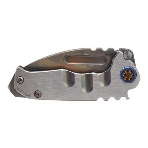 The Medford Micro Praetorian T 3V Vulcan Drop Point Blade Faced Silver Titanium Handle with a hole in the middle of it.