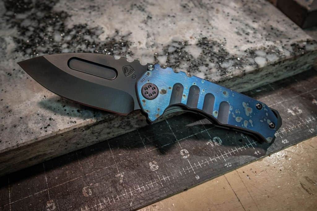a blue and black knife sitting on top of a table.