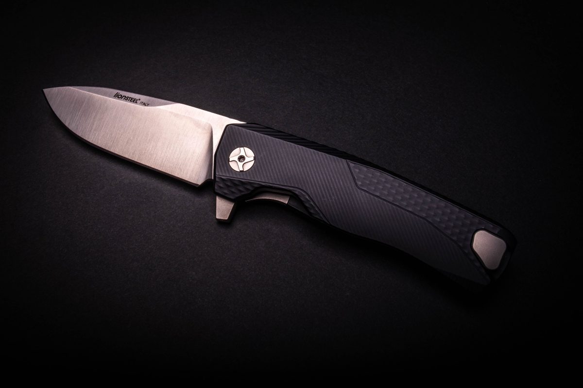 a knife with a black handle on a black surface.