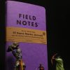 a purple book with miniature figurines in front of it.