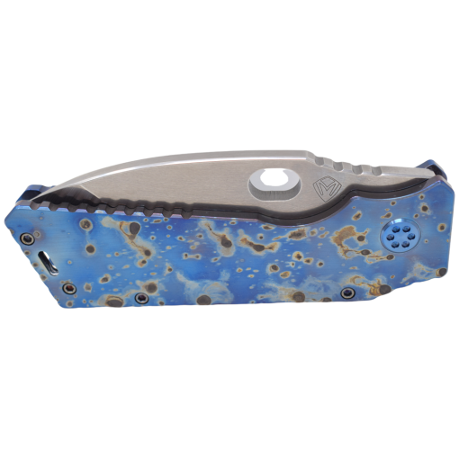 A Medford Fat Daddy Tumbled S35VN Drop Point Blade Faced and Flamed Galaxy Front Blue Anodized Spring Blue Hardware Brushed Blue Clip knife with holes in it.